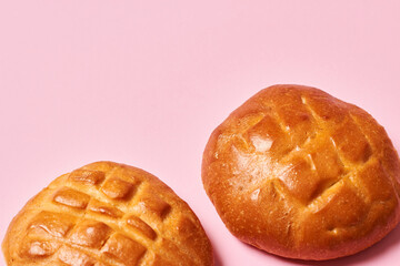 Two fresh baked sweet breads isolated on pink background with copy space. Horizontal photo. Food and health concept.