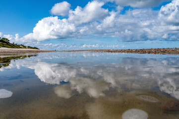 Obraz premium Reflection of clouds in the water. Beautiful sky. The sea coast. Deserted seashore.