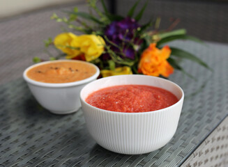 Healthy and delicious colorful homemade smoothie bowls served in bowls with flowers in the background.