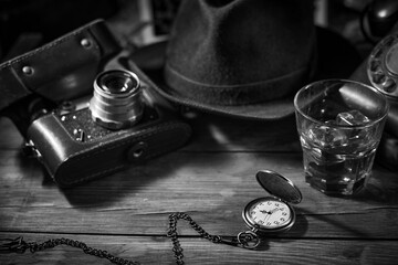 Old vintage cinematic noir scene, detective's desk with a hat, telephone, camera, portable cassette recorder, and whisky