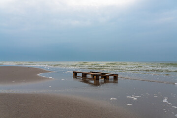 Wooden pallet thrown by waves on the beach