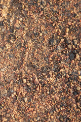 Dirt road made of small granite stones as a background.