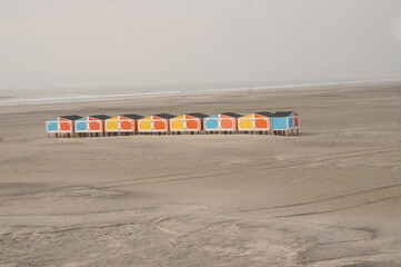 Orange Yellow and Blue Beach Lockers on Sandy Beach with Ocean and Blue Sky 101421 - obrazy, fototapety, plakaty