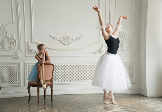 Two ballerinas in a beautiful hall. Experience skill and study