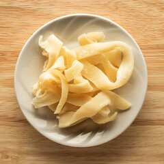 Dried squid rings in a plate on a wooden table. Top view. Snacks for seafood beer.