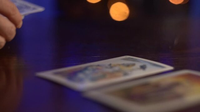 Female hands lay out and turn over Tarot cards on the table