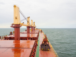 Dry bulk carrier ship with crane crab and towers at sea, deck view
