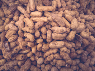Dried peanuts in pods on the store shelf in light focus