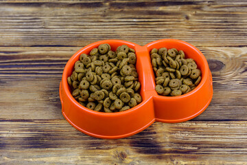 Bowl with pet food on a wooden background