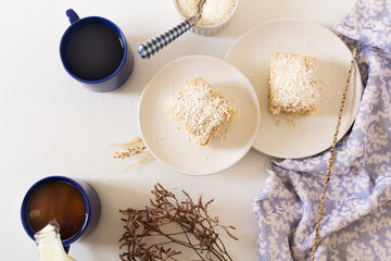 Breakfast beige cozy composition with coconut cake. Flat lay, top view