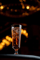 Rum cola cocktail on a dark bar counter  with bokeh lights on a background