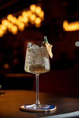 Elegant gin cocktail on dark wooden bar counter, stylish cocktail photo for socials