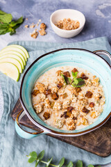 Oatmeal with muesli and apple on a wooden board