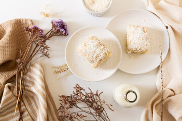 Breakfast beige cozy composition with coconut cake. Flat lay, top view