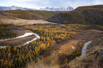 Mountain landscape on the background of a road with a car and a mountain river in autumn. Altai,...