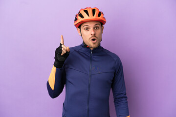 Young Brazilian cyclist man isolated on purple background intending to realizes the solution while lifting a finger up