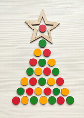 Christmas tree made from kids wooden mosaic on a wood white table.