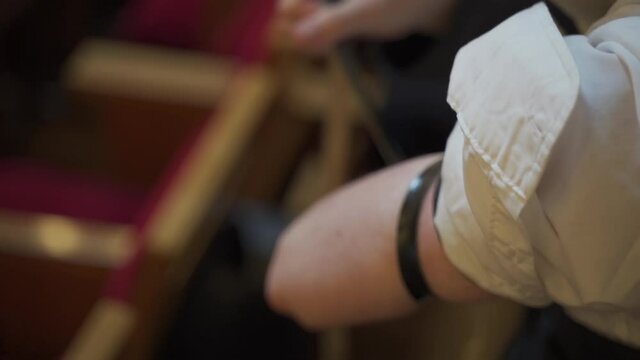 A young man, a Jew, puts on tefillin. Prayer in the synagogue.