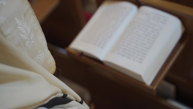 An old man, a Jew praying, reading a book. Close-up of a book.
