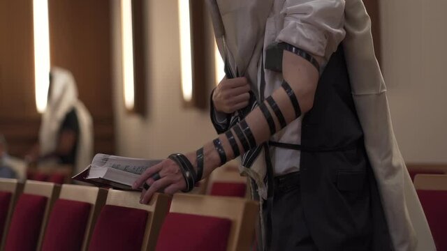 An adult man, a Jew, is reading a book standing up. Prayer, tefillin, tallit, 