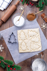Making Christmas tree shaped puff pastry cookies with sugar and cinnamon, cutting the dough