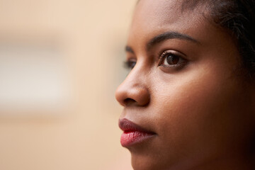 Close up portrait of attractive African American woman's eyes looking outside through window.