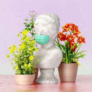 Marble greek bust with disposable mask and blooming flowers