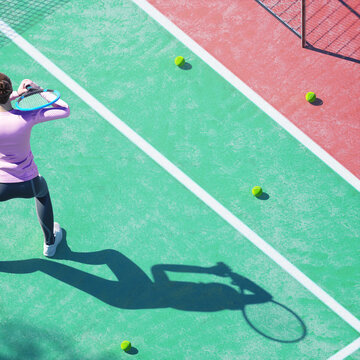 Aerial view of woman practicing tennis on the court