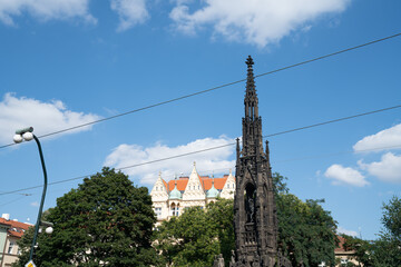 Obraz premium Black Gothic church spire, overhead tram cables in Prague, Czech Republic