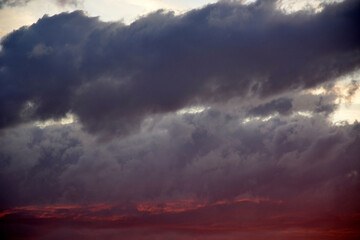 Crimson sunset. Sky with red and dark clouds.