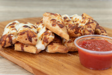 Side dish of cheese sticks bread with marinara sauce for dipping, are the perfect appetizer for a hearty meal to eat