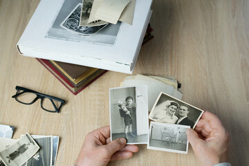an elderly man looks through his old photographs of 1950-1955, the concept of nostalgia and...