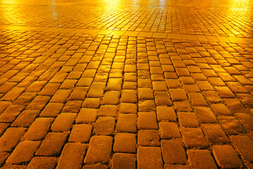 Golden hue at night on empty cobbled street