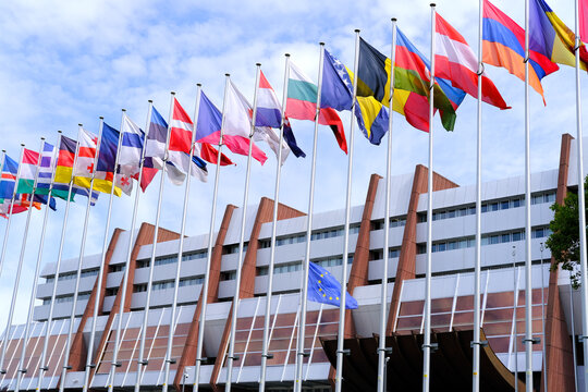 Strassbourg, France, August 2021: many national flags in front of building of international organization Council of Europe, concept of standards of law, human rights and cultural interaction