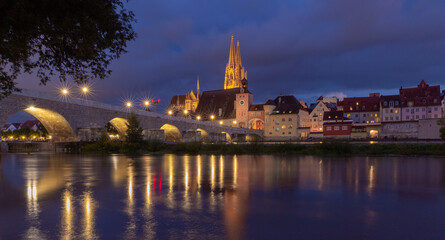 Fototapeta na wymiar Regensburg. Old stone bridge over the Danube river in the night light.