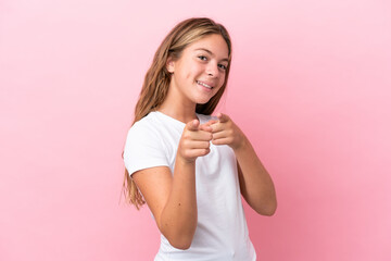 Little caucasian girl isolated on pink background surprised and pointing front