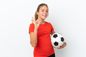 Little caucasian girl isolated on white background with soccer ball and making OK sign