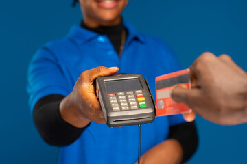 black lady holding a pos device and someone stretching a credit card towards it