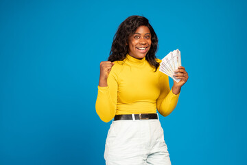 excited and happy black woman holding some money