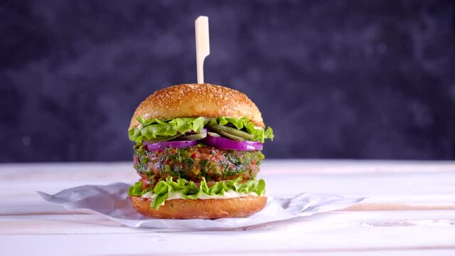 Vegan burger on a white table and with a dark blue background. Vegetable meat. Ready to eat. 