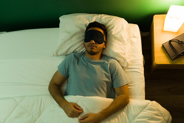 Tired man sleeping with an eye mask