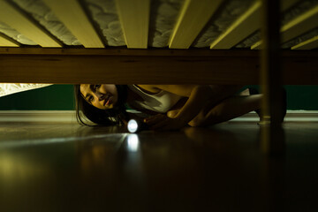 Beautiful woman searching under the bed