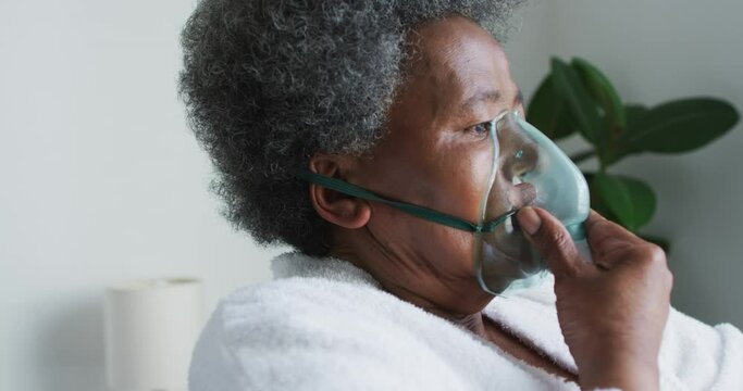 African american senior woman breathing using an oxygen mask at home