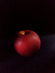 Fototapeta na wymiar red apple on black background, dark image.