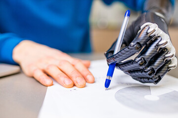 man with prosthetic hand writing development at home