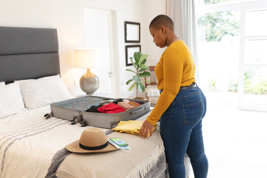 African american plus size woman packing suitcase for travel