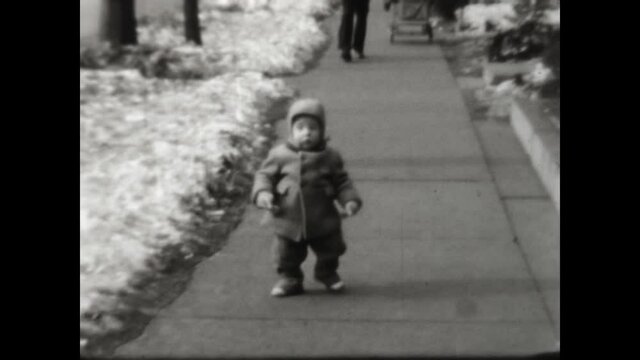 Toddler Walking Cute 1952 - A cute toddler walks on the sidewalk.
