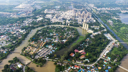 Flood waters overtake a house and rice field at Central of Thailand in 2021. Many buildings are submerged in water. Photo disaster from above view by drone