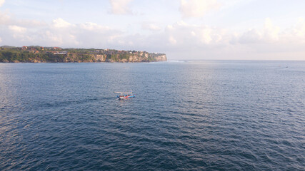 view of the ocean boat travel adventure sunset sunrise Bali Indonesia cliffs Uluwatu adventure explore vacations sea clouds sky drone view