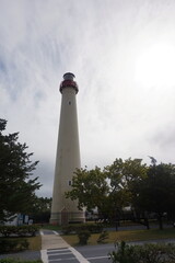 Beige Lighthouse Against Blue Clouded Sky with Greenery 